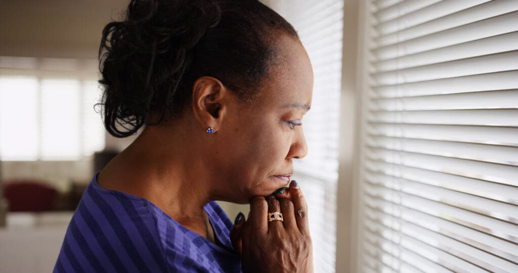 A sad woman at a window