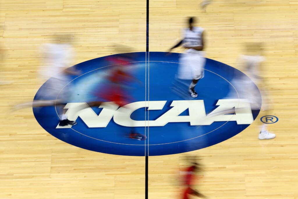 An NCAA logo in the center of a basketball court