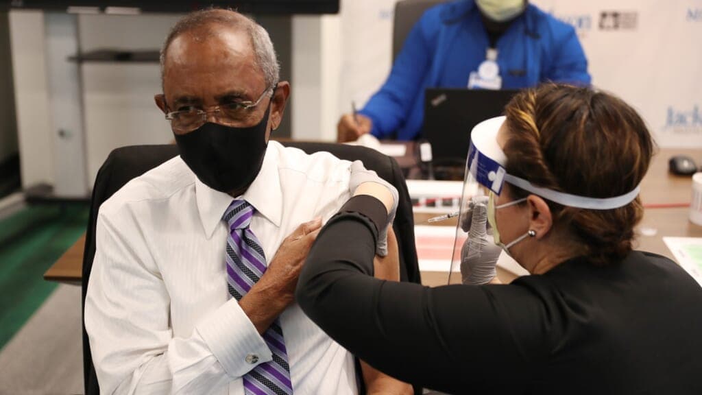 Patrick Range Sr. receives a COVID-19 vaccine from RN Susana Flores Villamil