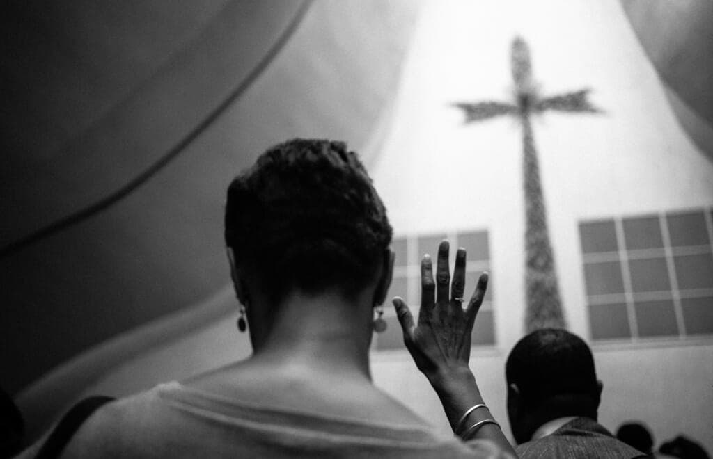 A woman raises her hand in a church