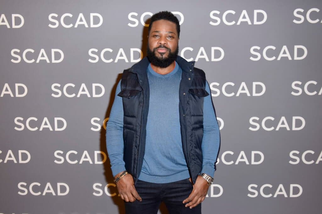 Actor Malcolm-Jamal Warner wearing a blue shirt and navy vest