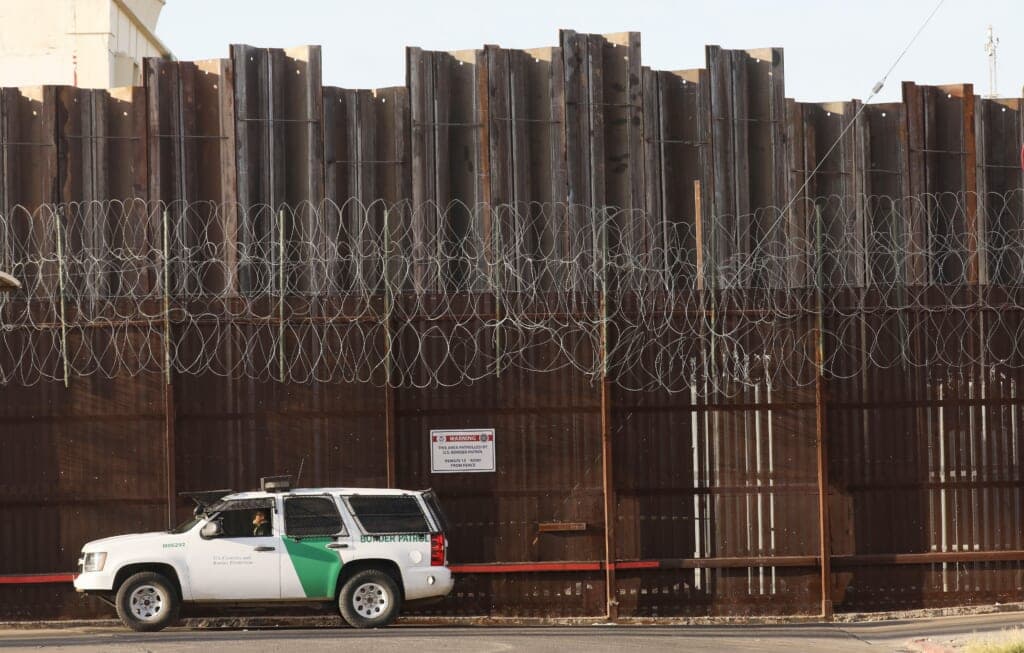 A Border Patrol agent is posted in front of the U.S.-Mexico border barrier