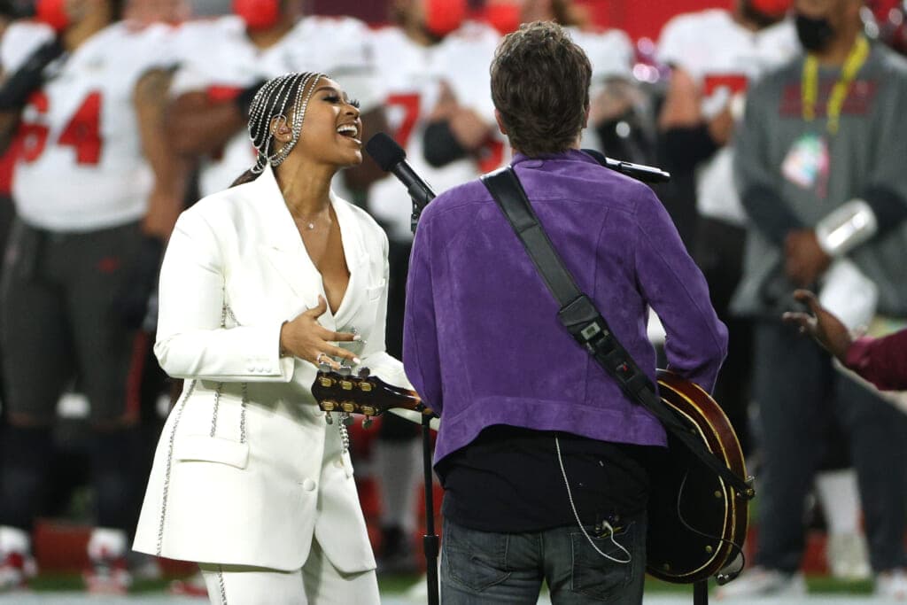 Singers Jazmine Sullivan and Eric Church perform the national anthem before Super Bowl LV
