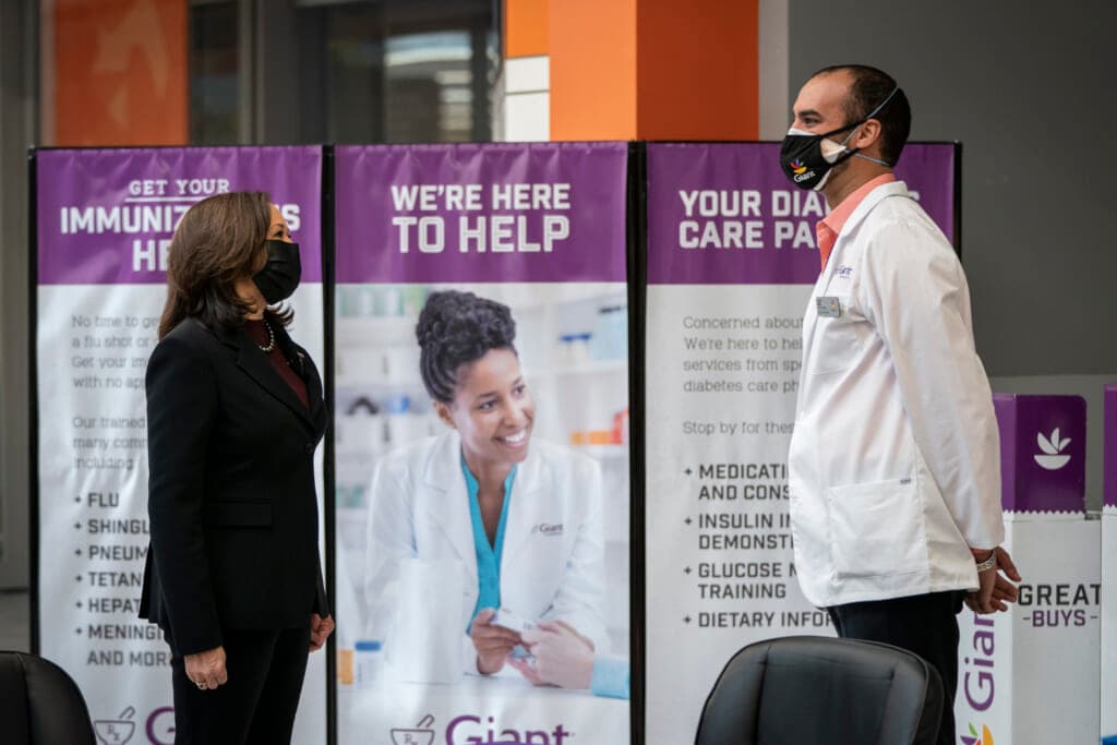Vice President Kamala Harris speaks with pharmacist Samir Balile