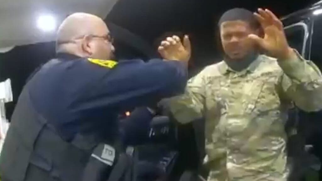 Army Second Lt. Caron Nazario raises his hands during a traffic stop