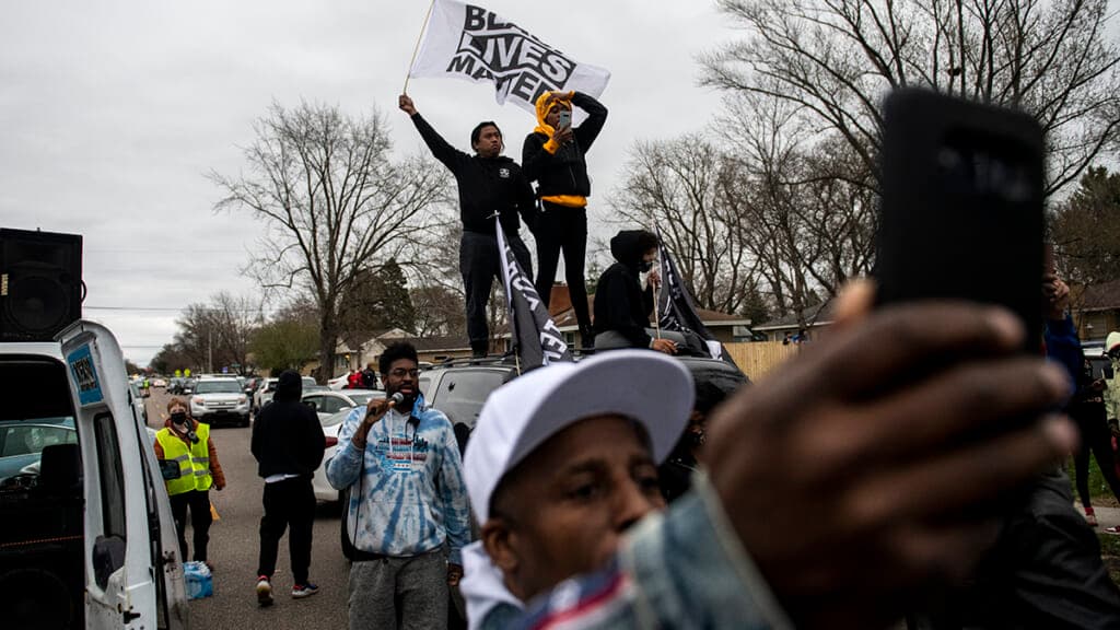 A group of people with a "Black Lives Matter" flag