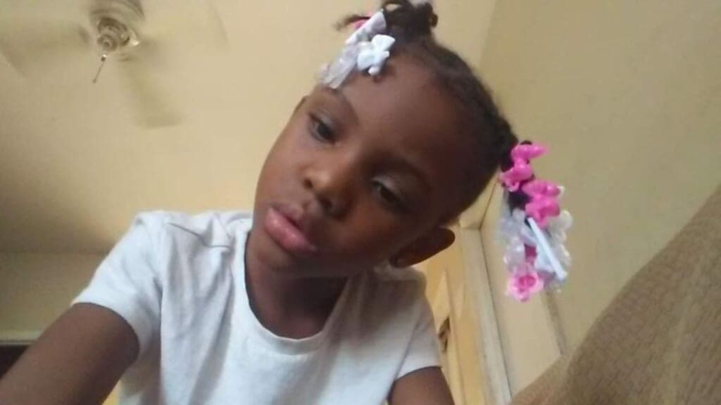 Jaslyn Adams in a white top with white and pink barrettes in her pigtails