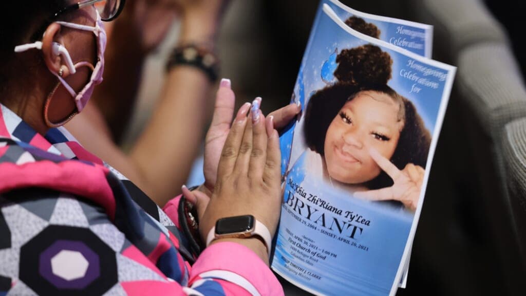 A woman holds a funeral program for 16-year-old Ma’Khia Bryant