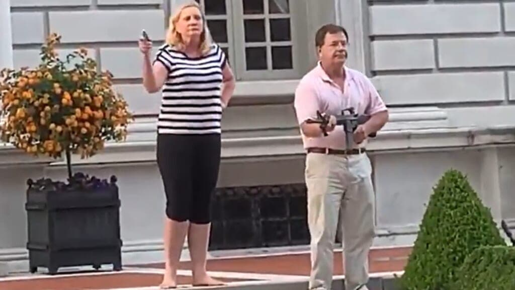 Patricia and Mark McCloskey in front of their St. Louis home pointing guns at Black Lives Matter protesters
