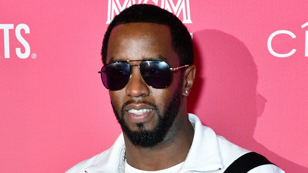 Sean Love "Diddy" Combs wearing a white jacket and sunglasses