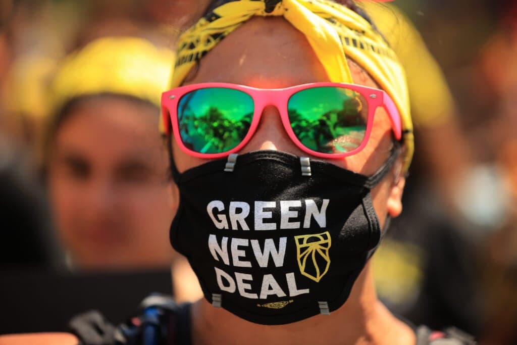 A young climate activist wearing a "Green New Deal" mask