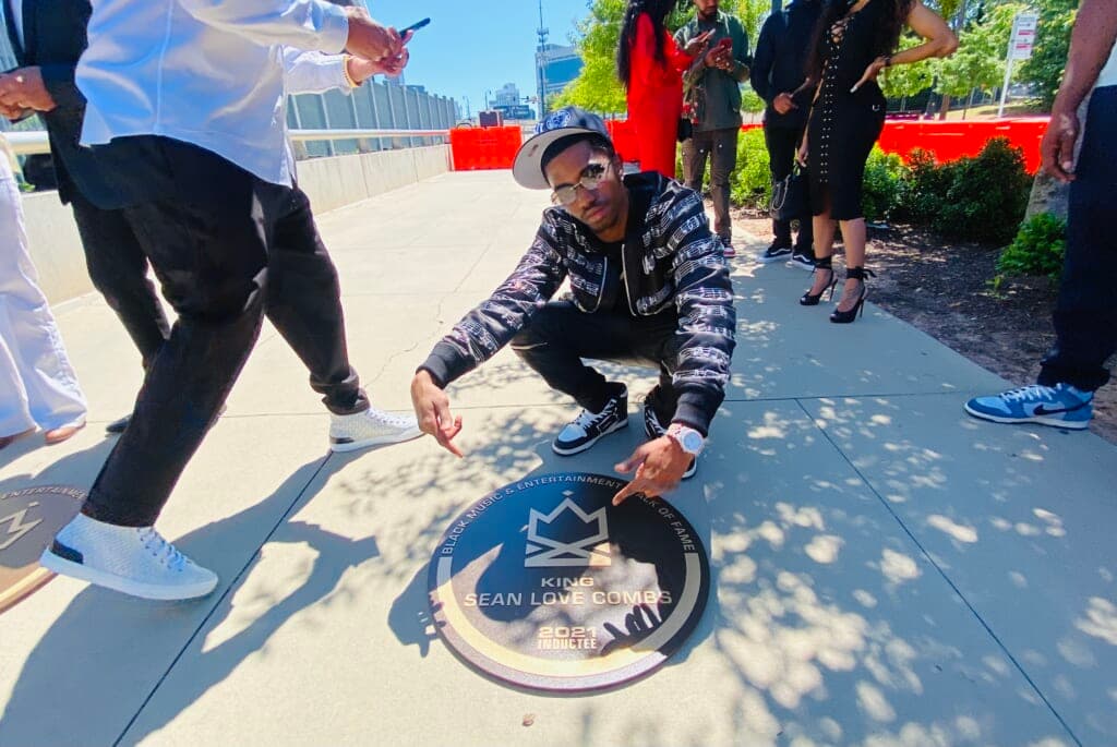 Christian Combs, son of Sean Love Combs, poses next to a crown jewel honoring his father
