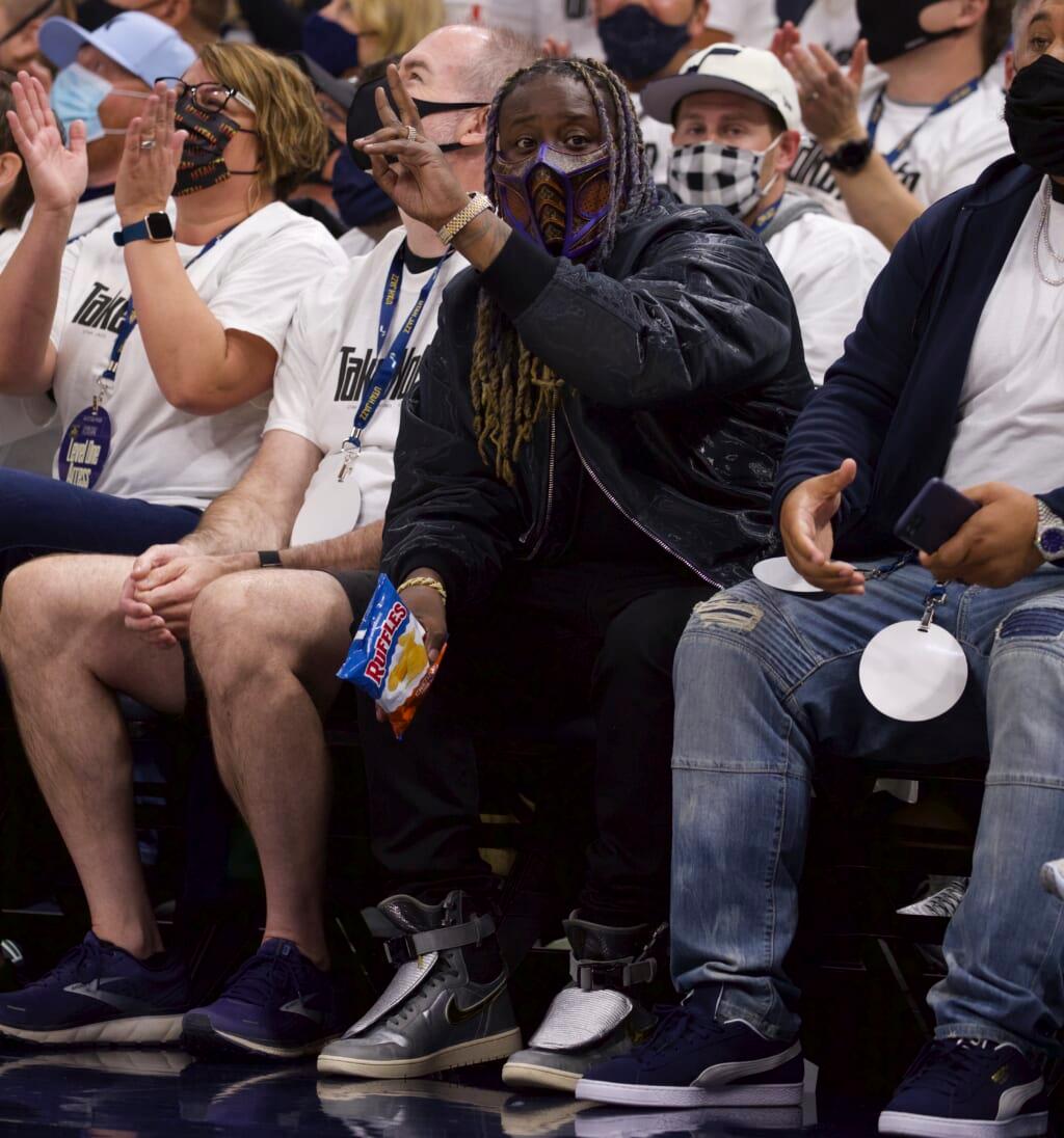Rapper T-Pain sits courtside wearing all black
