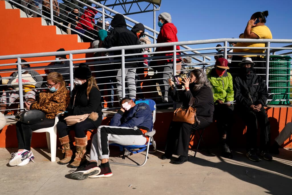 People wait in line to receive a $250 grocery gift card