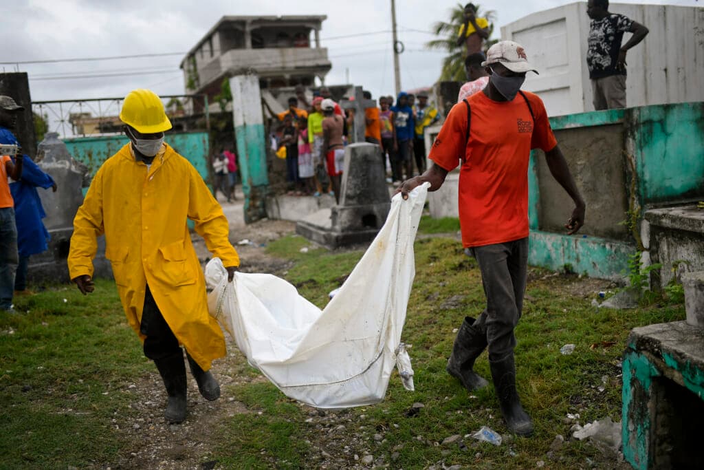 Men carry the body of a boy killed in an earthquake