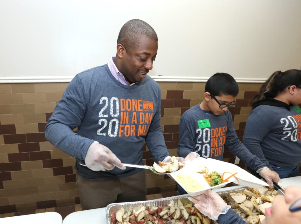 State Senator Brian A. Benjamin of New York serving food