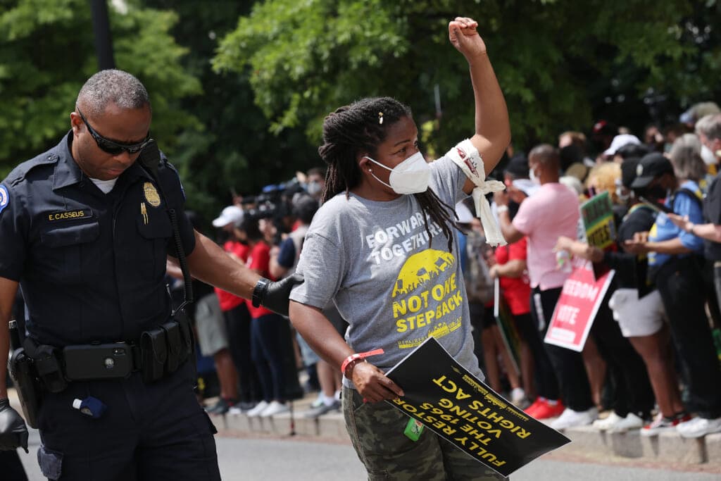 Capitol Hill Police officers escort a protester arrested outside the Hart Senate Office Building