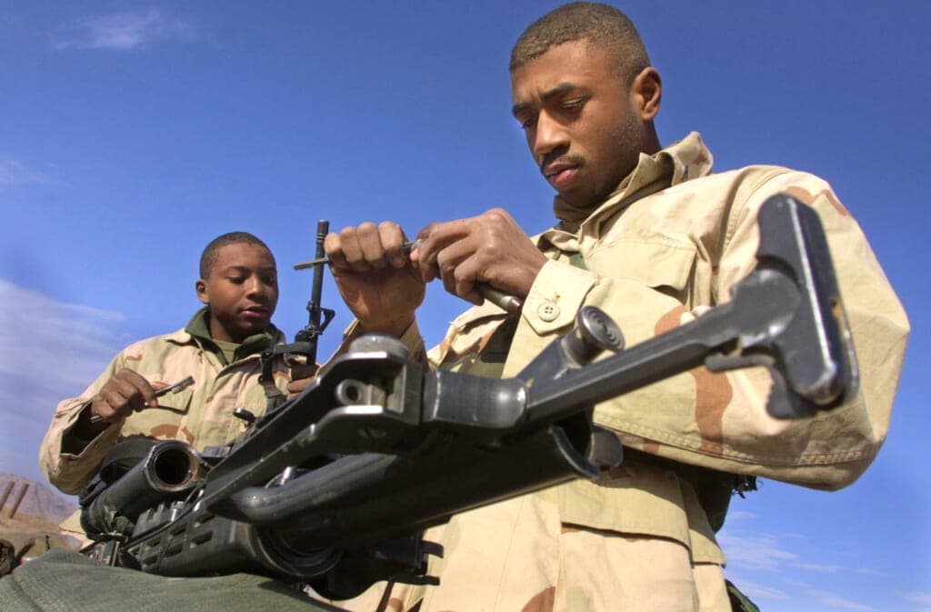 U.S. Marine Sargeant Carl Garnett and Lance Corporal Travis McKenzie clean their rifles