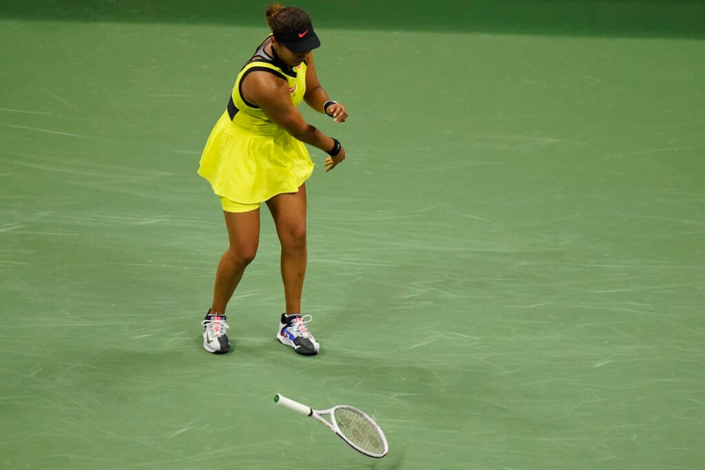 Tennis player Naomi Osaka throws her racket down during a match