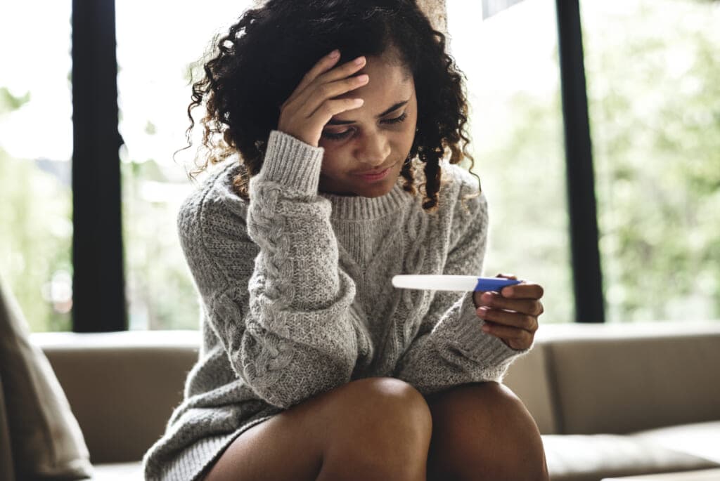 A woman looks at a pregnancy test