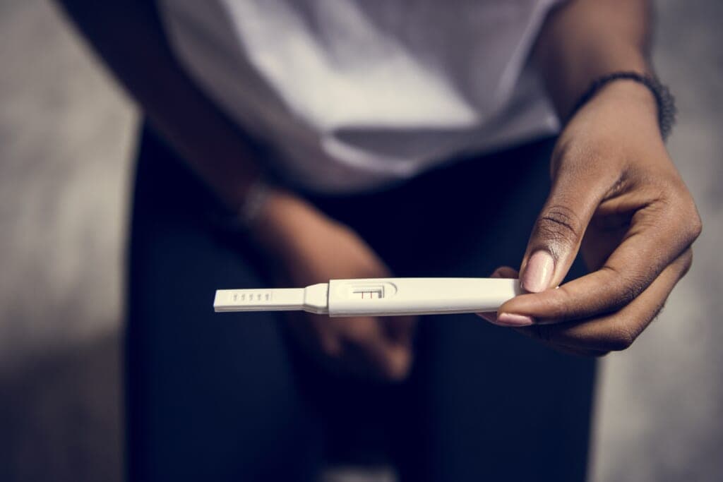 Closeup of black woman with pregnancy test in a hand
