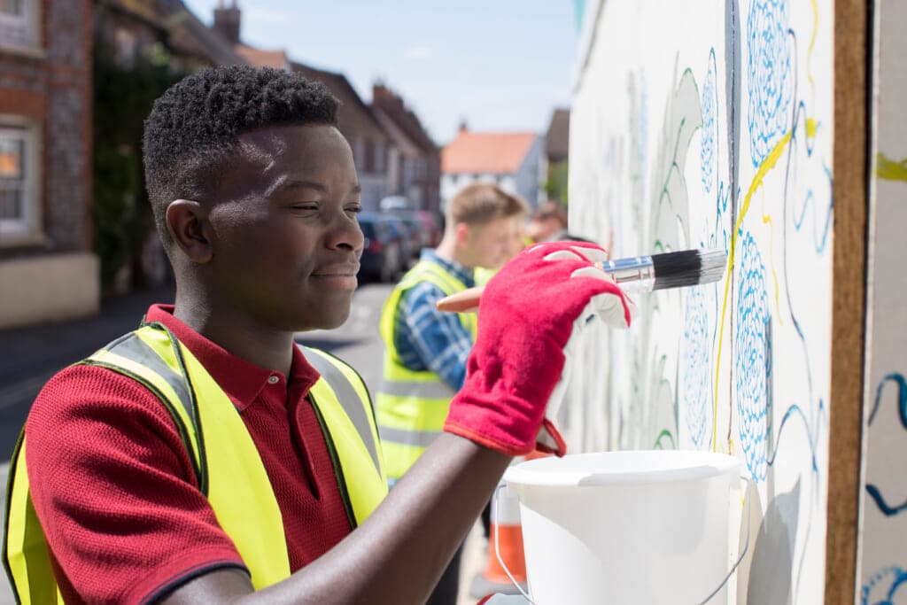 Group of helpful teenagers creating and maintaining Community Art Project