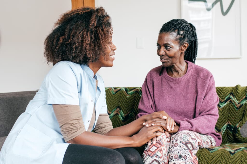 A caregiver sits with a woman