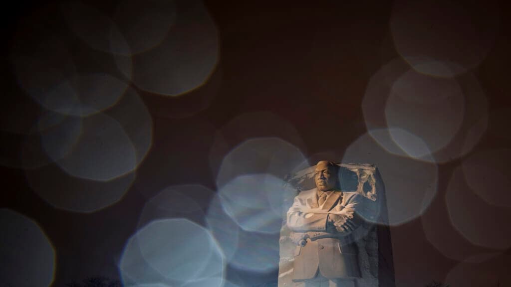 Lights from a snowplow illuminate sleet at the Martin Luther King Jr. Memorial in Washington