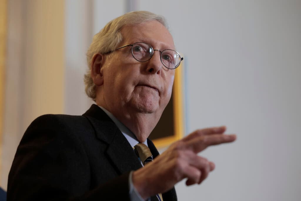 Republican Senate Minority Leader Mitch McConnell of Kentucky is shown gesturing, wearing a black jacket and brown tie