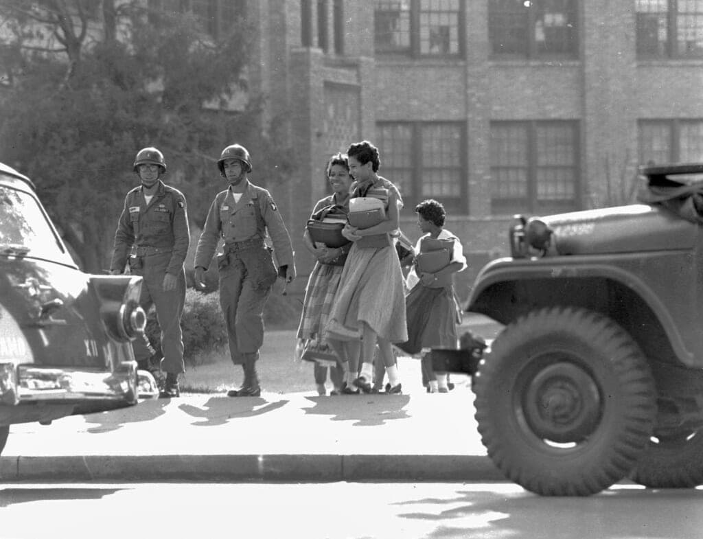 Two paratrooper officers escort black students