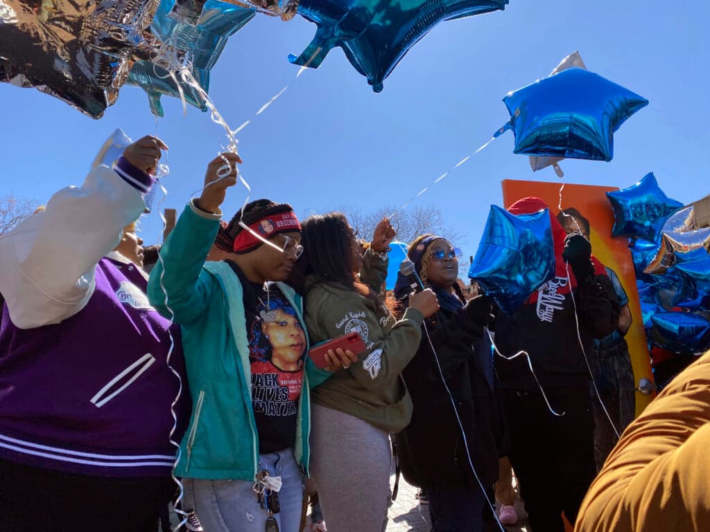 Several people hold Mylar blue star balloons