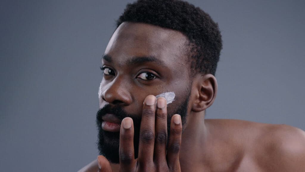 A man putting shaving cream on his face