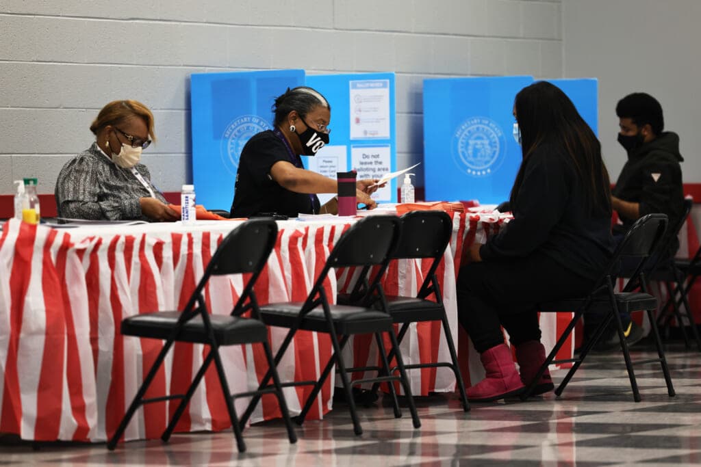 People check in as they prepare to cast their vote in the Georgia runoff election