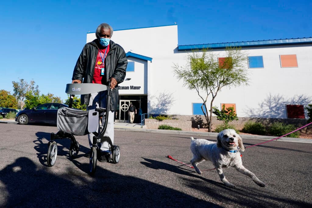 Lovia Primous walks across the street from Ozanam Manor temporary housing