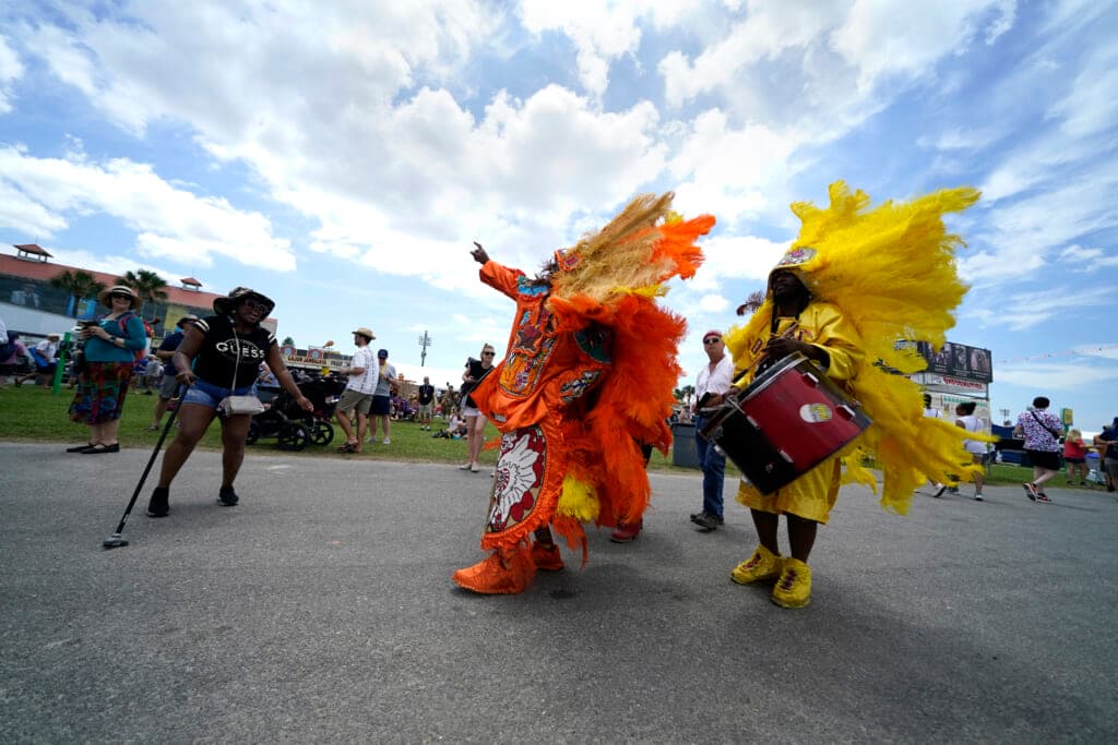 Members of the New Orleans Mardi Gras Indian tribe Wild Mohicans wearing orange and yellow feathered costumes