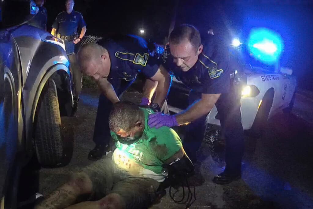 Louisiana State Police Troopers Kory York and Chris Hollingsworth hold up Ronald Greene, wearing a green shirt
