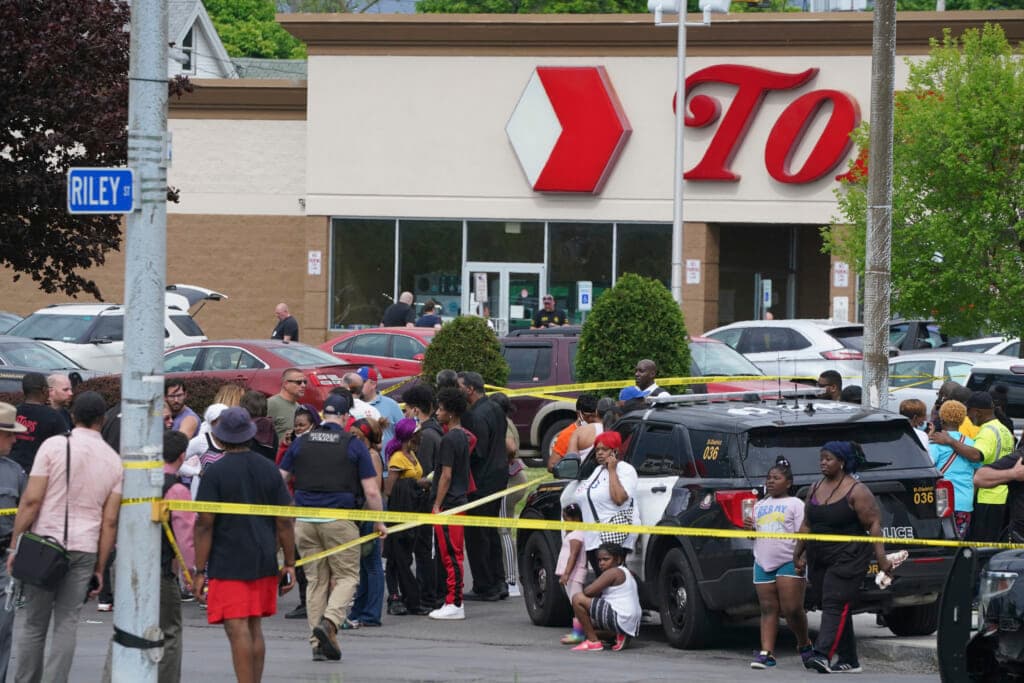 People gather outside a supermarket where several people were killed