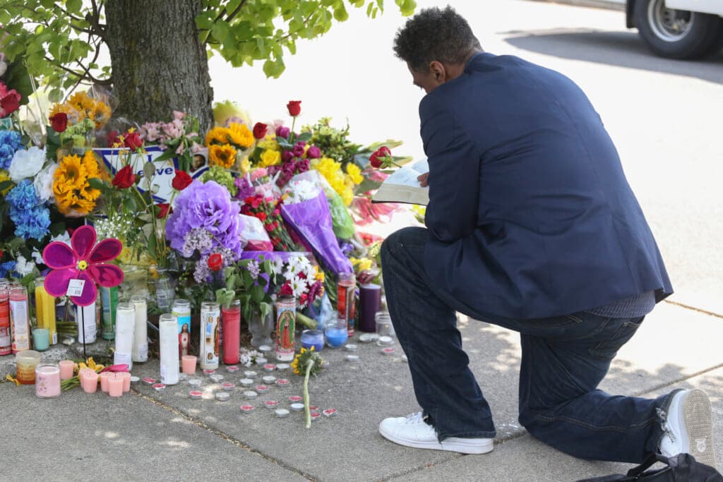 A man reads scripture at a memorial honoring shooting victims