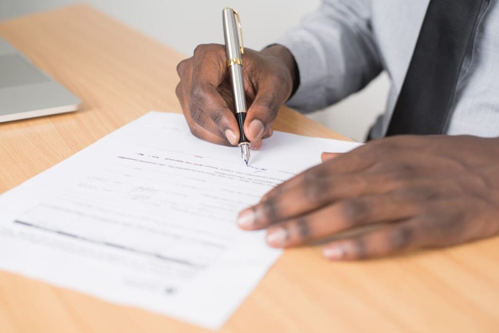 Hands writing with a pen on a piece of paper
