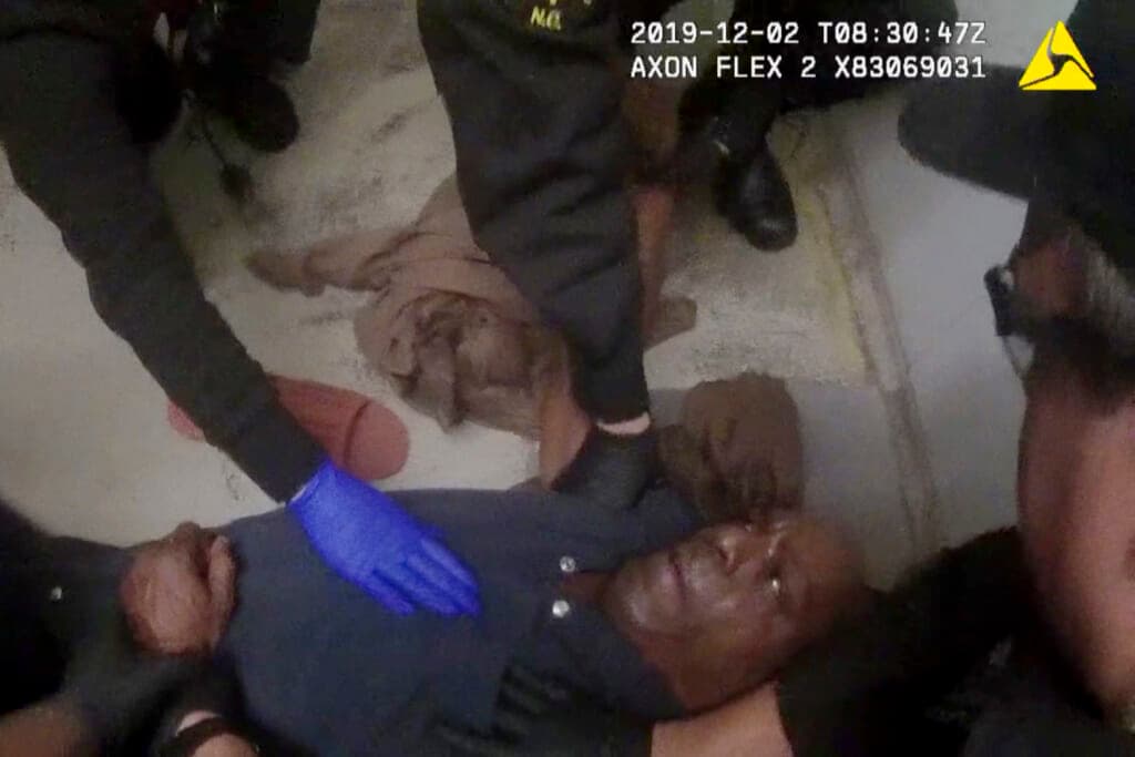 Authorities restrain John Neville in his cell