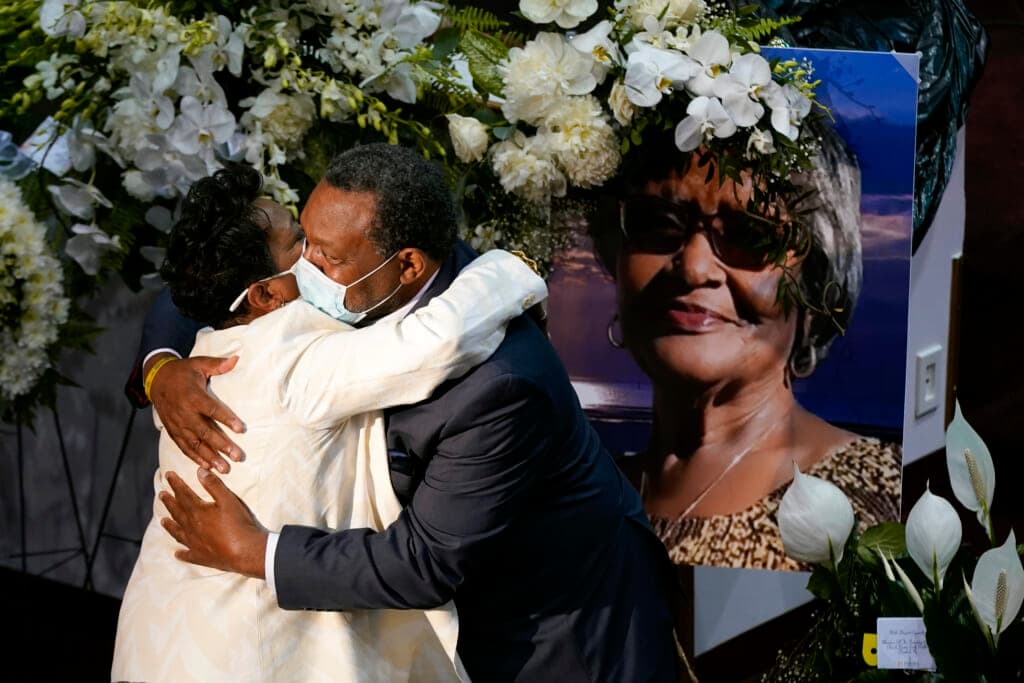 A mourner embraces Angela Crawley, daughter of Ruth Whitfield