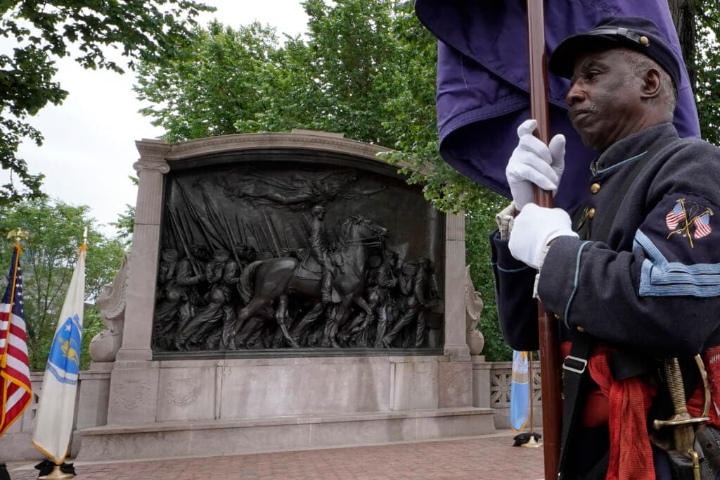 Civil War reenactor Larry Harris marches past the Robert Gould Shaw and the 54th Massachusetts Regiment Memorial
