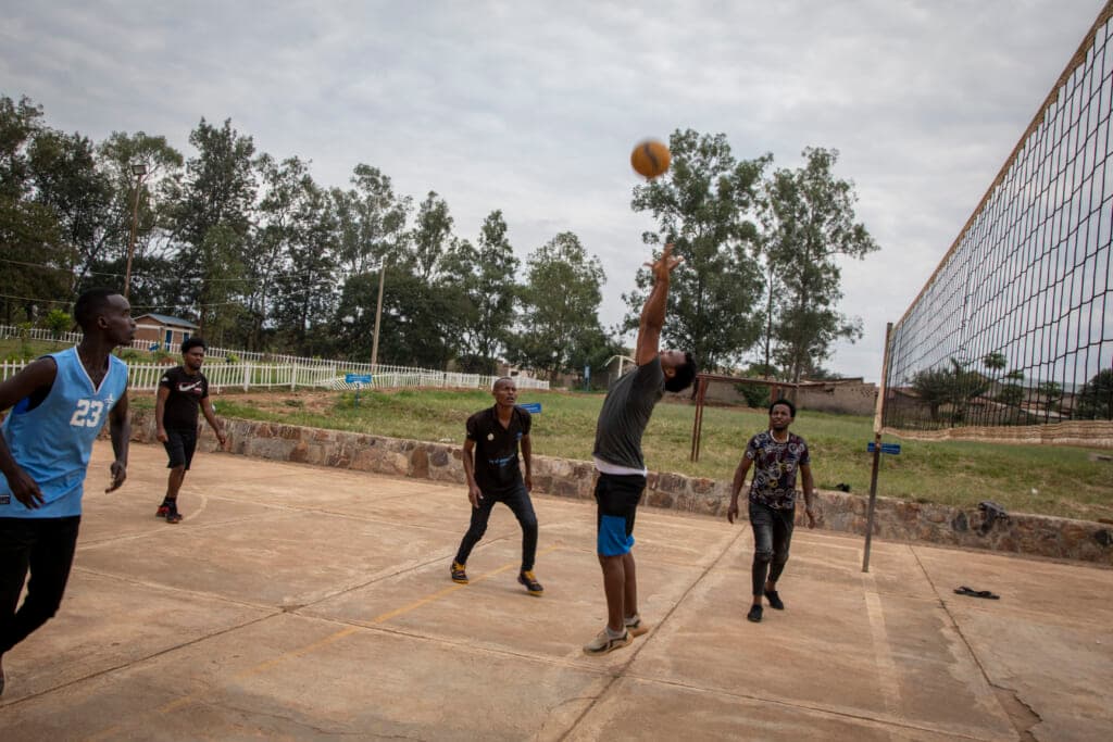 Men who were evacuated from Libya to Rwanda play volleyball