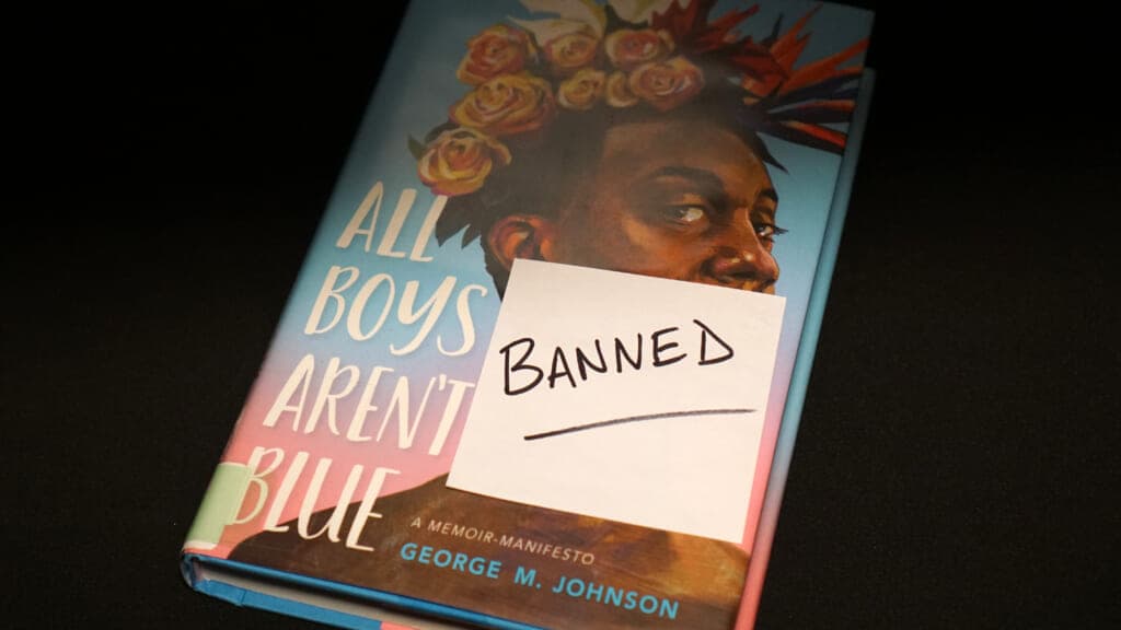 The book "All Boys Aren't Blue" with a sticker reading "BANNED"