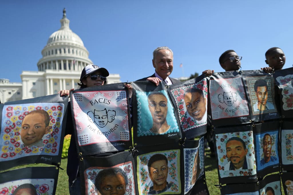 Senate Minority Leader Charles Schumer (D-NY) (center) with students holding portraits of gun violence victims