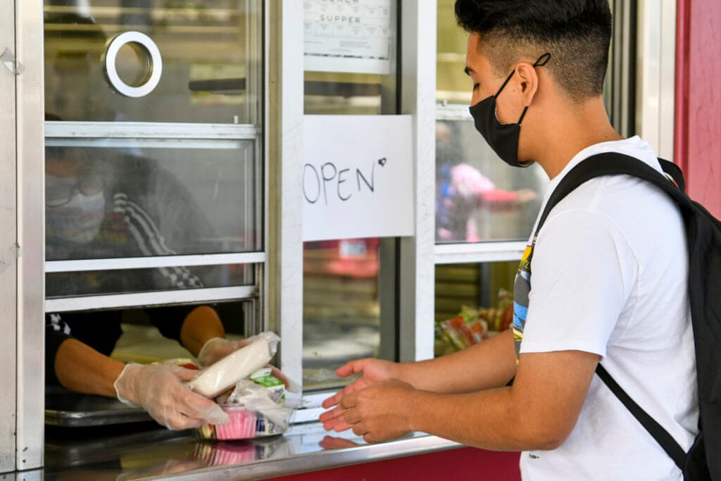 A returning student receives pre-packaged lunch at Hollywood High School