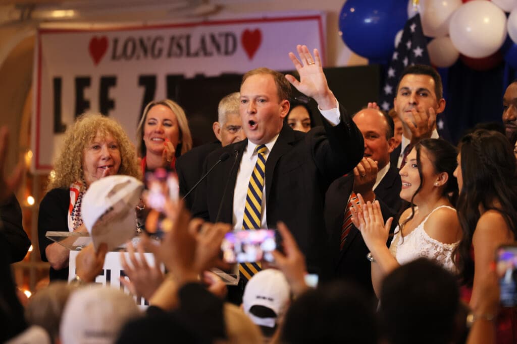 New York Republican gubernatorial candidate Rep. Lee Zeldin raises his hand as he speaks behind a podium