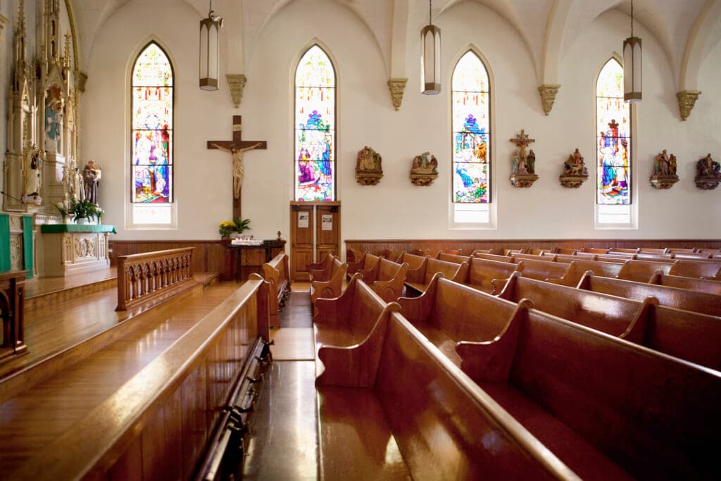 Interior of a church with a crucifix and stained-glass windows