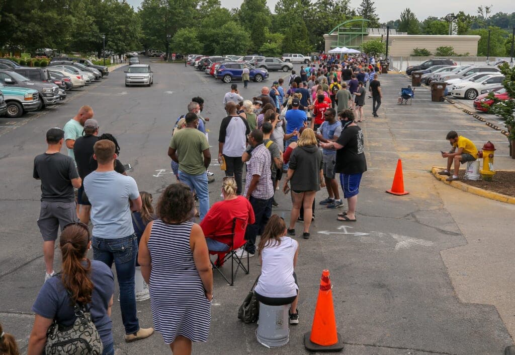 A long line of people near a parking lot