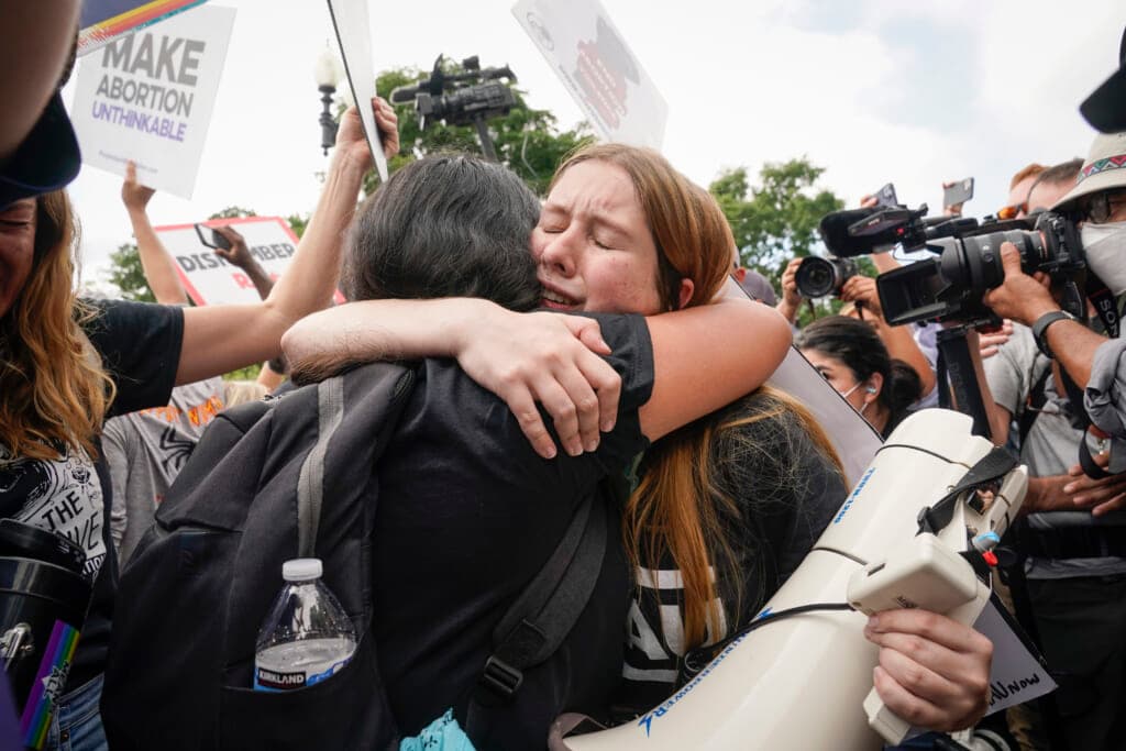 Women embrace moments after the Supreme Court overturned Roe v Wade